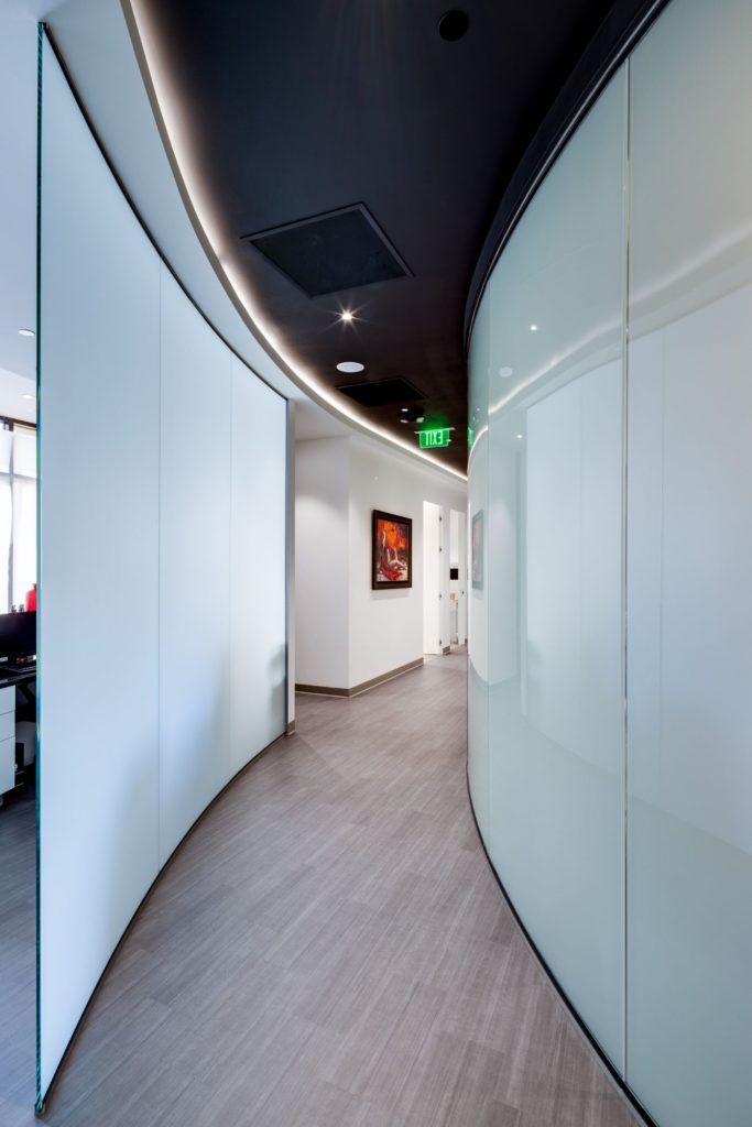 Modern corridor with curved glass walls.
