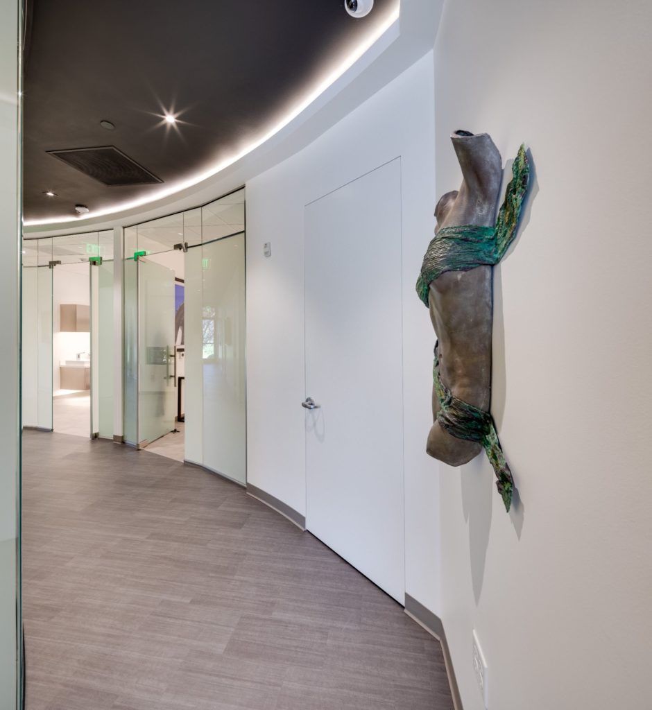 Modern hallway with sculpture on wall.