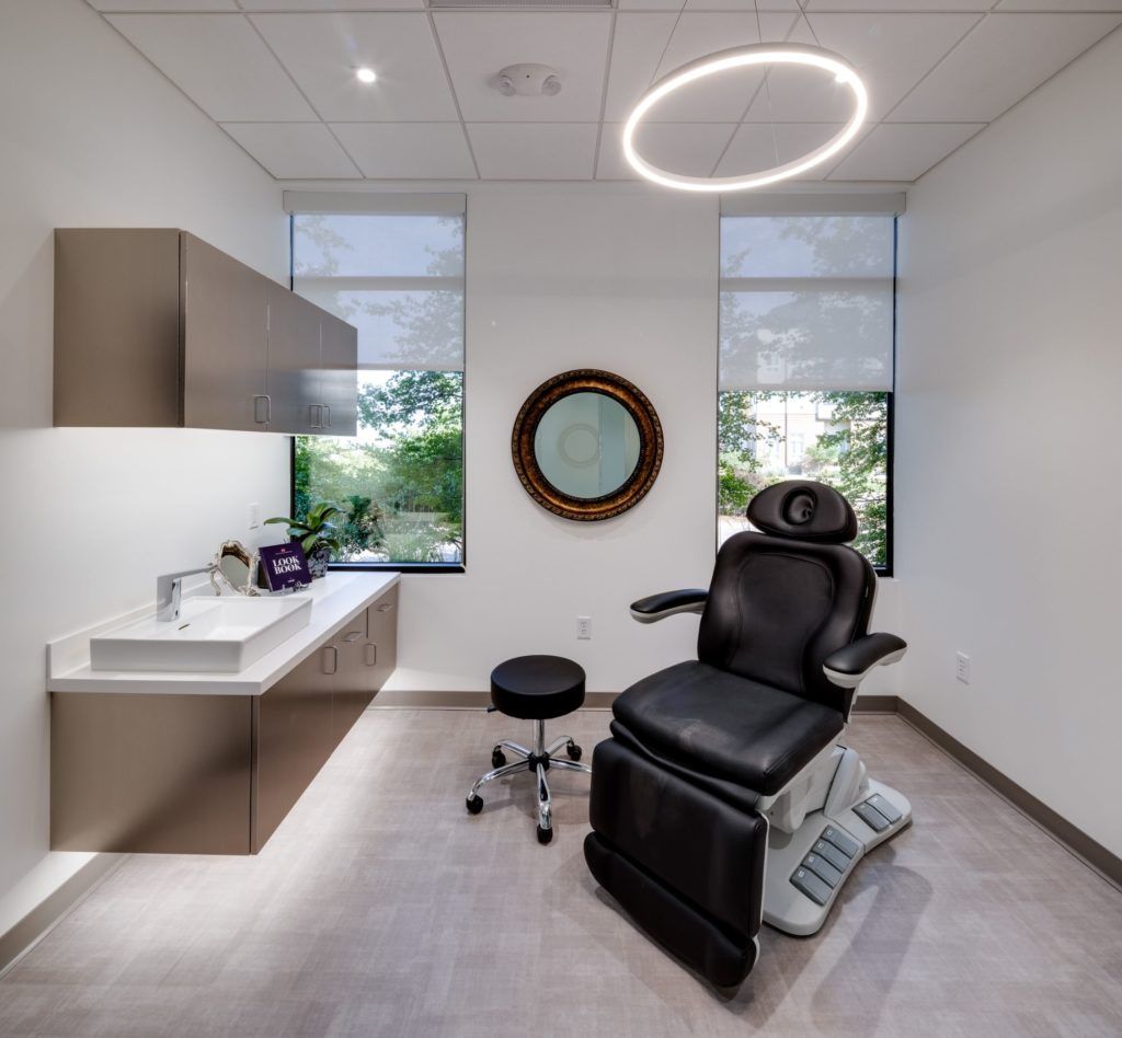 Modern medical office with examination chair and natural light.