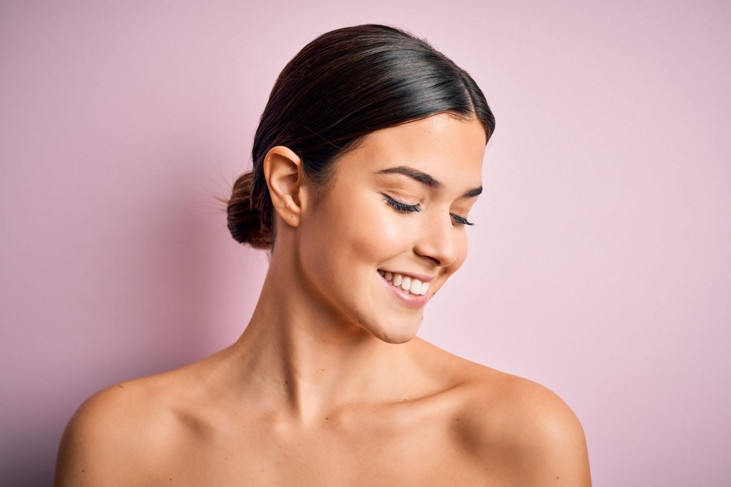 Smiling woman with a pink background.