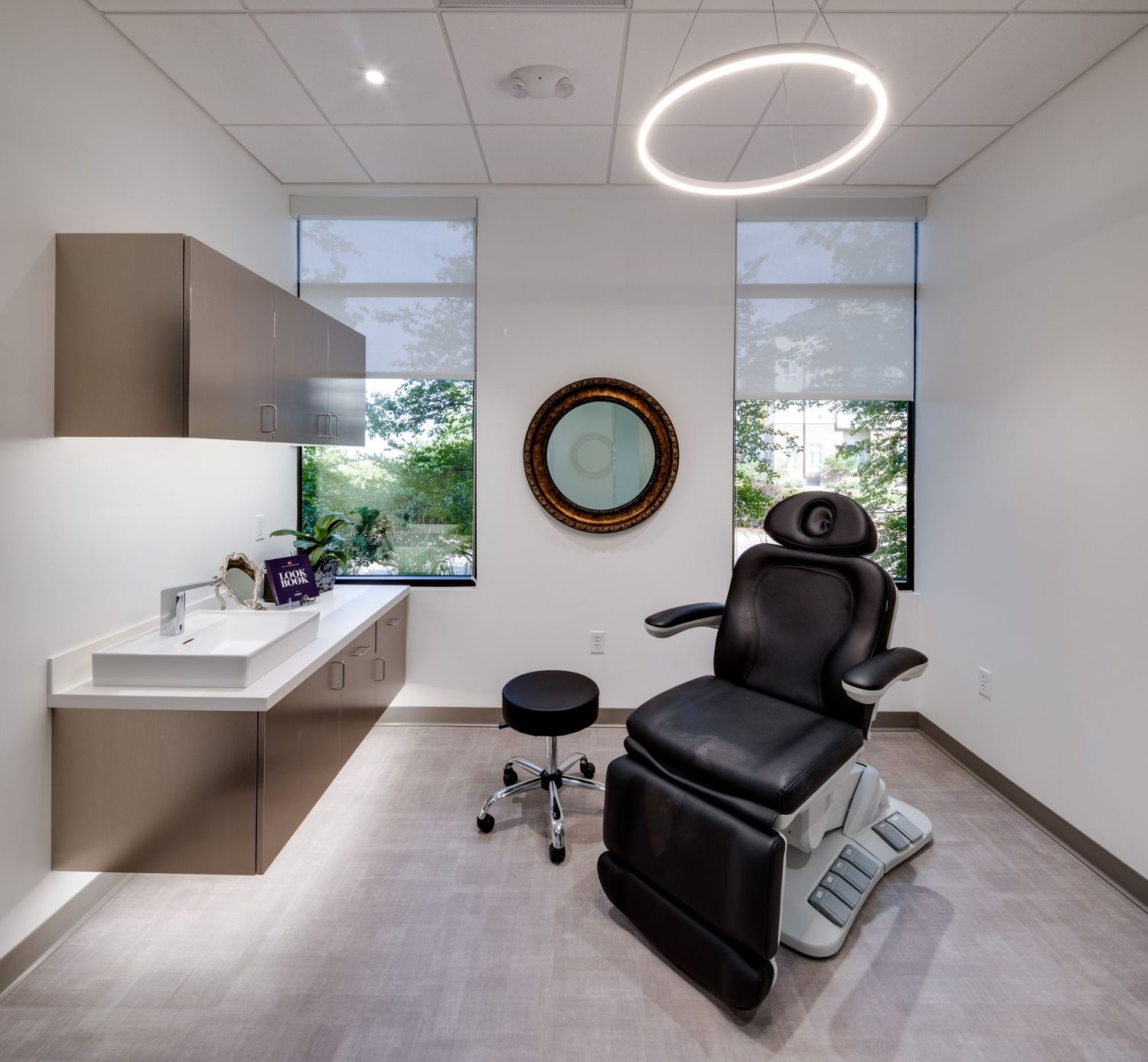 Modern examination room with dental chair and lighting.