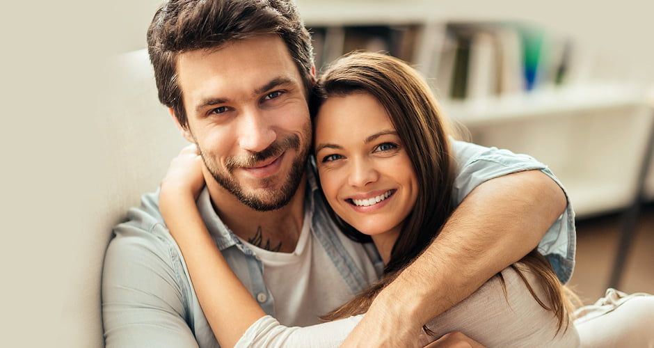 Happy couple embracing and smiling together.