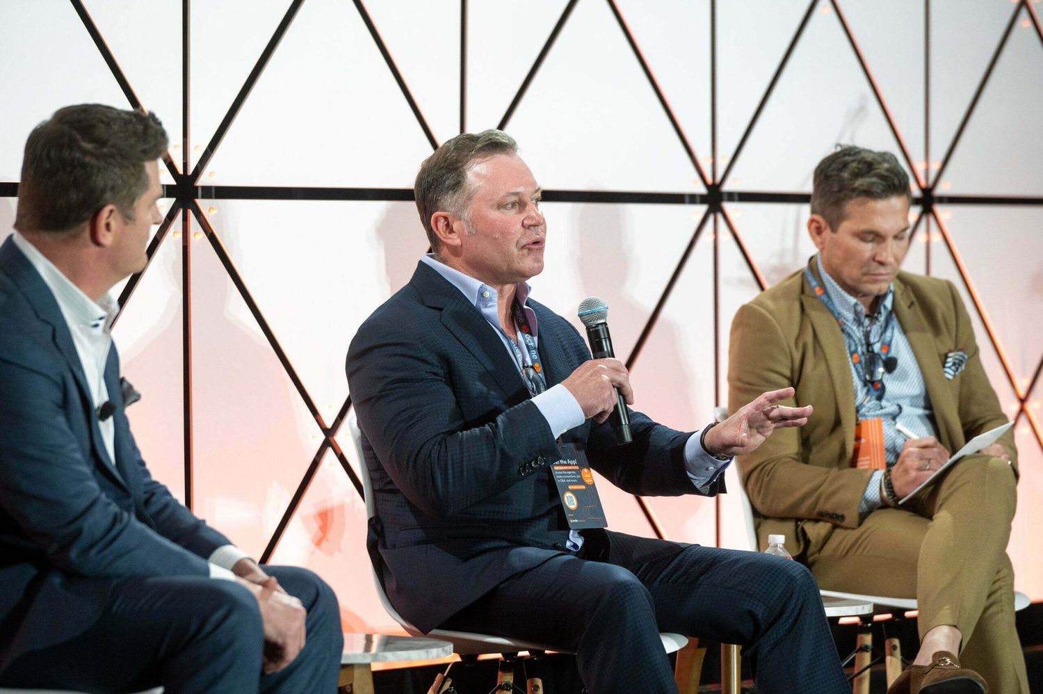 Panel discussion with three men on stage.