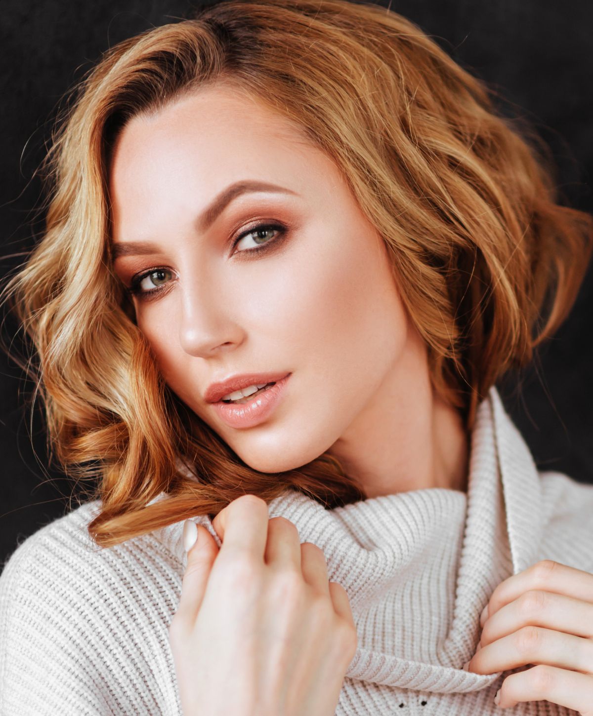 Woman with stylish hair in cozy sweater.