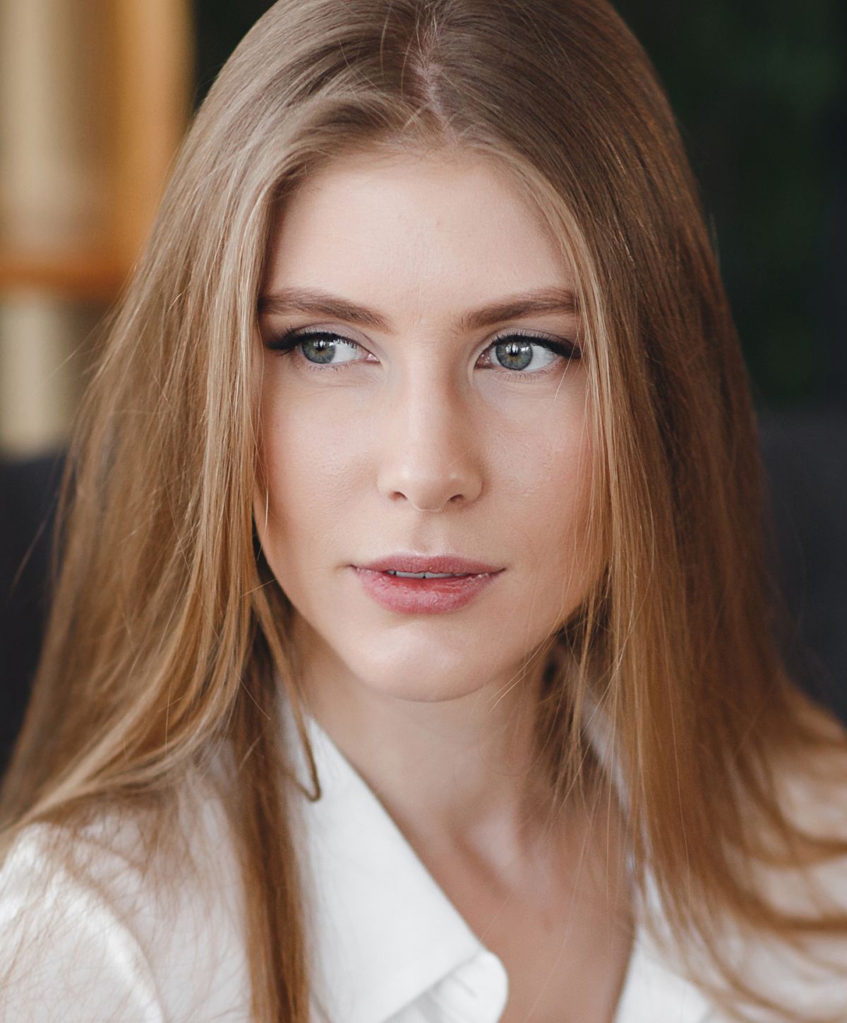 Woman in black bra gazing out window.