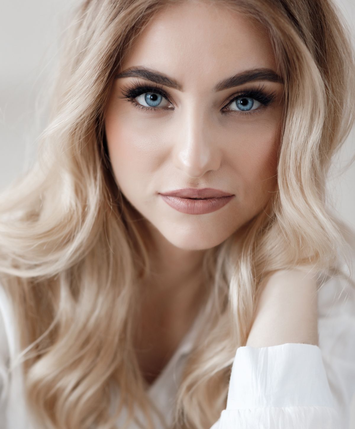 Woman in black bra gazing out window.