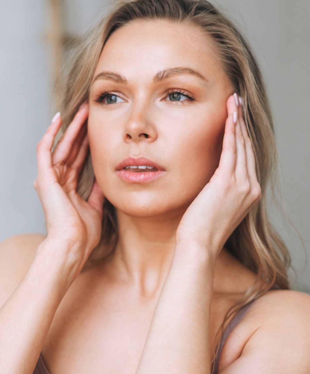 Woman gently touching her face, natural beauty.