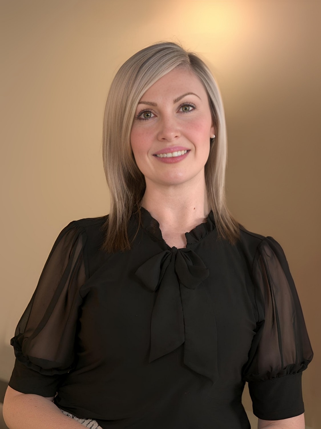 Woman smiling in stylish black blouse.