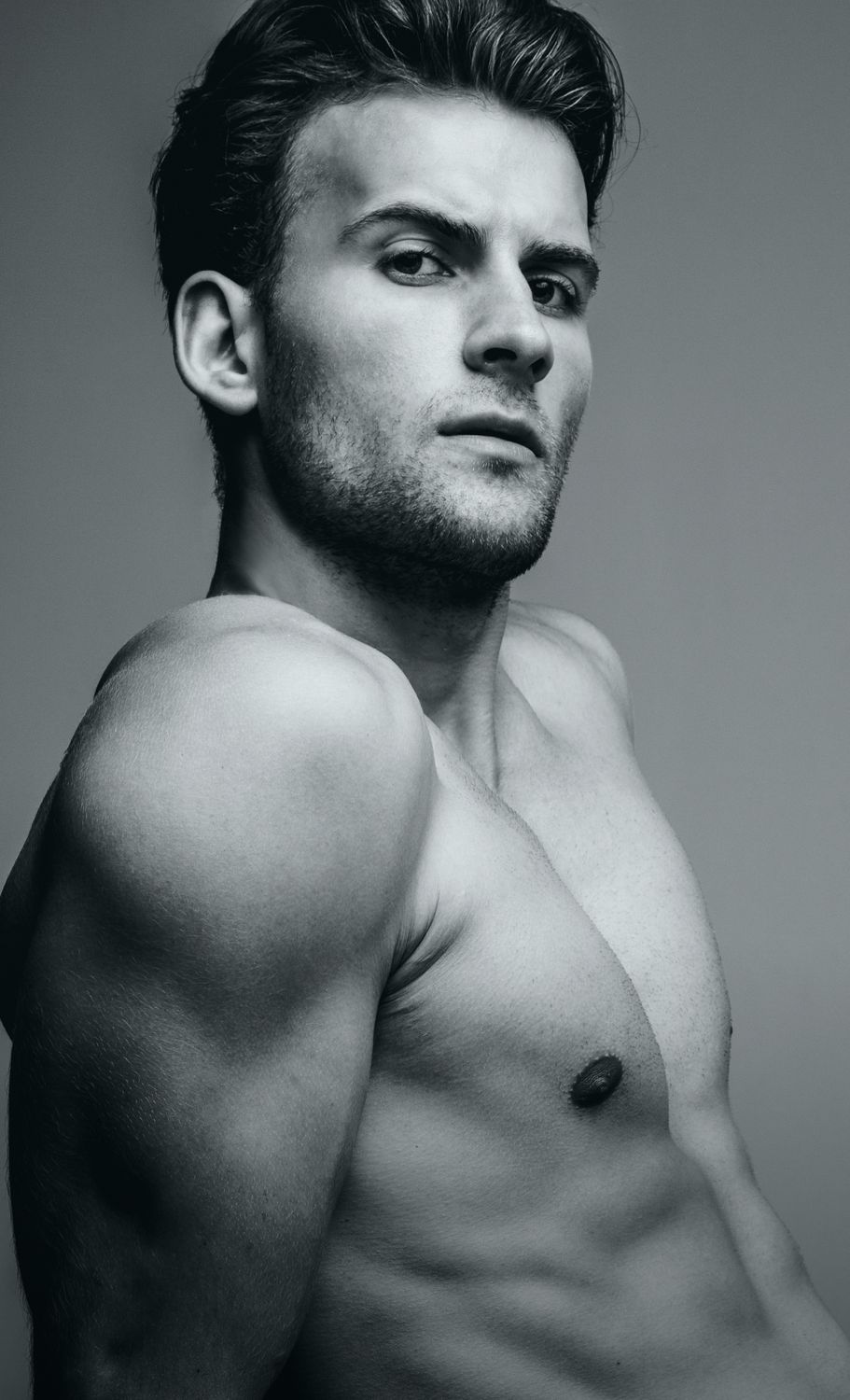 Black and white portrait of a muscular Denver plastic surgery male model.