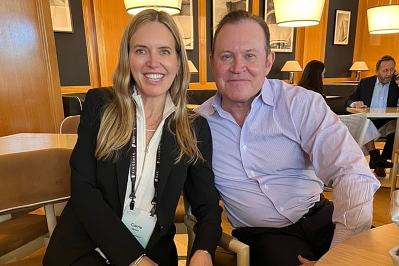 Two people smiling at a cafe table.