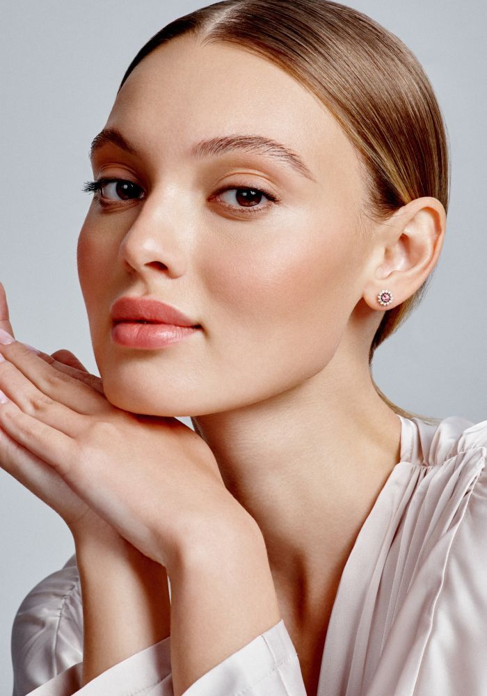 Model showcasing elegant earrings and natural beauty.
