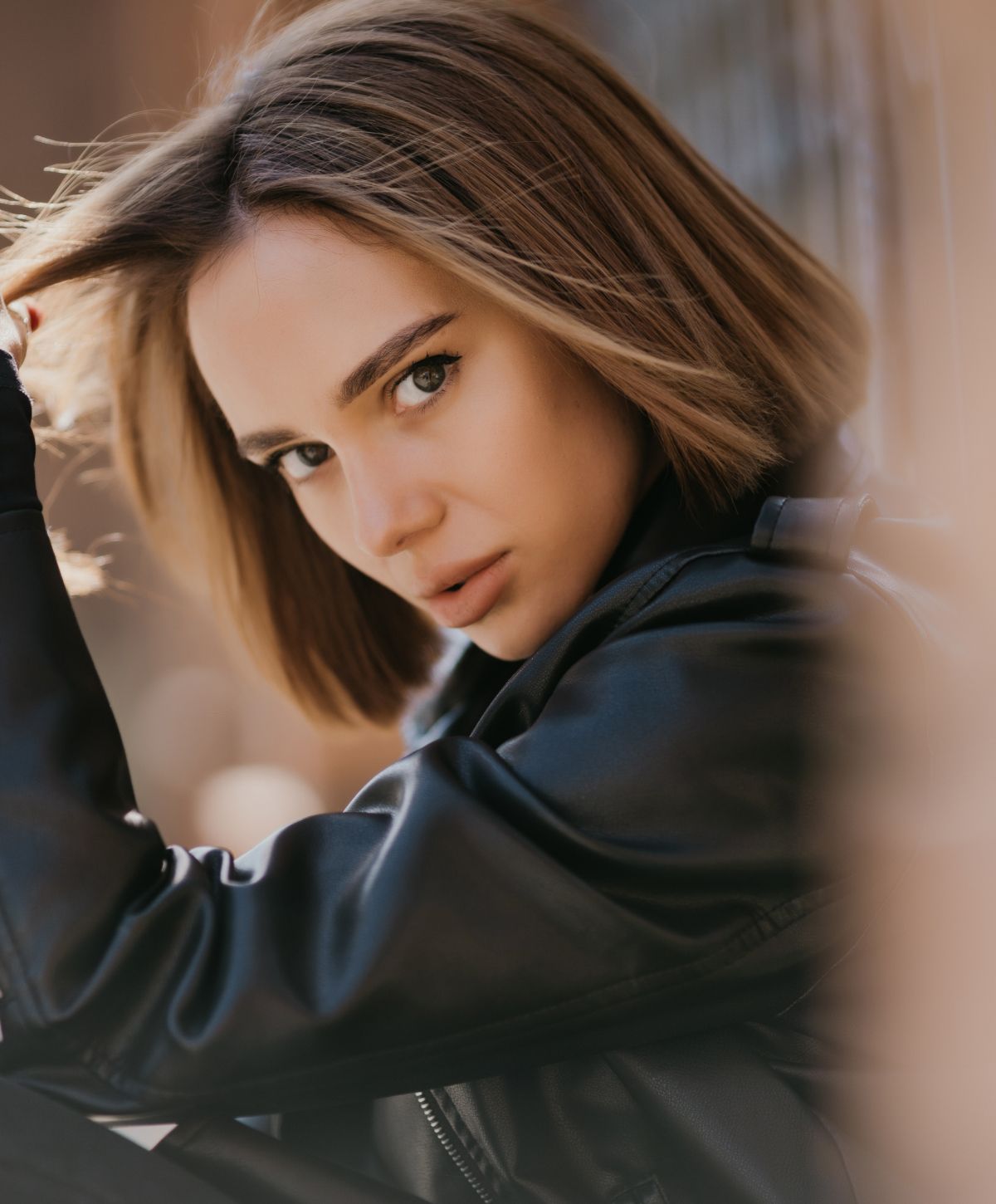 Woman with short hair in leather jacket.