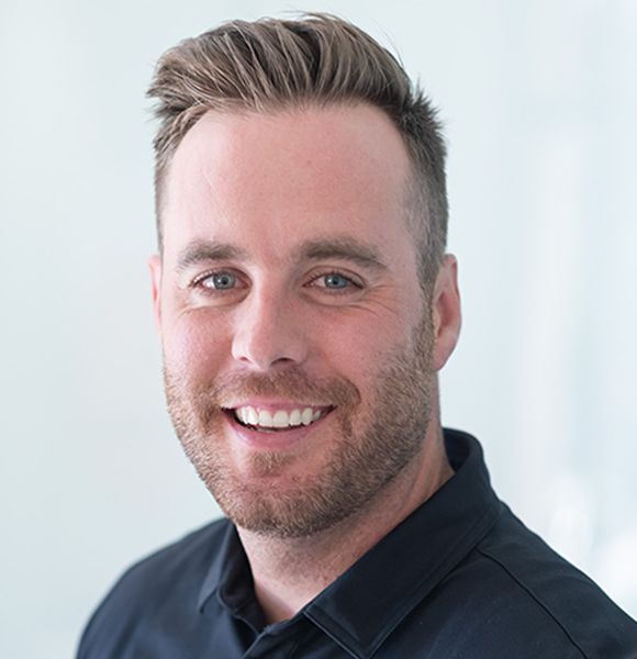 Smiling Denver plastic surgeon with short hair and beard.