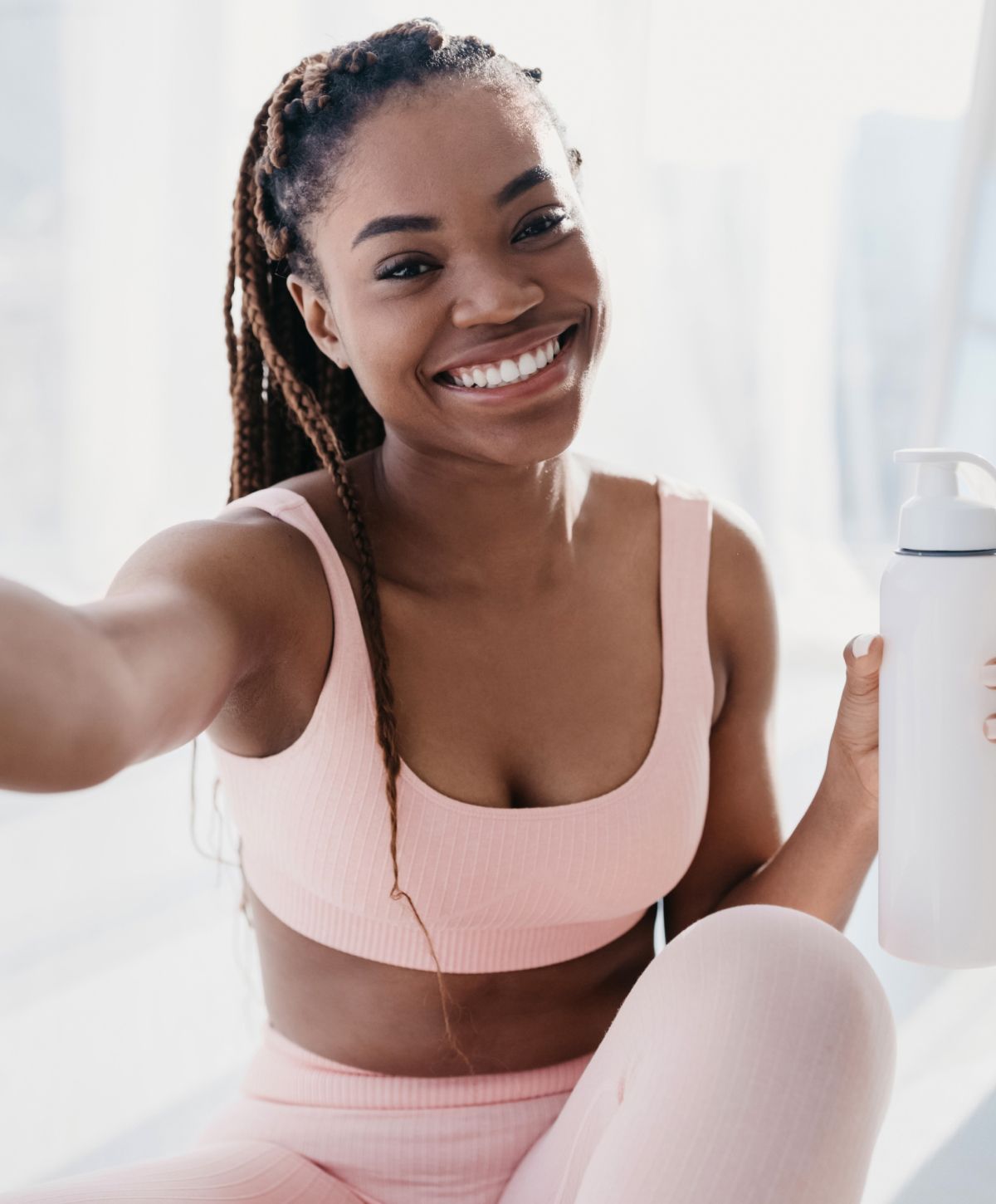 Woman in black bra gazing out window.