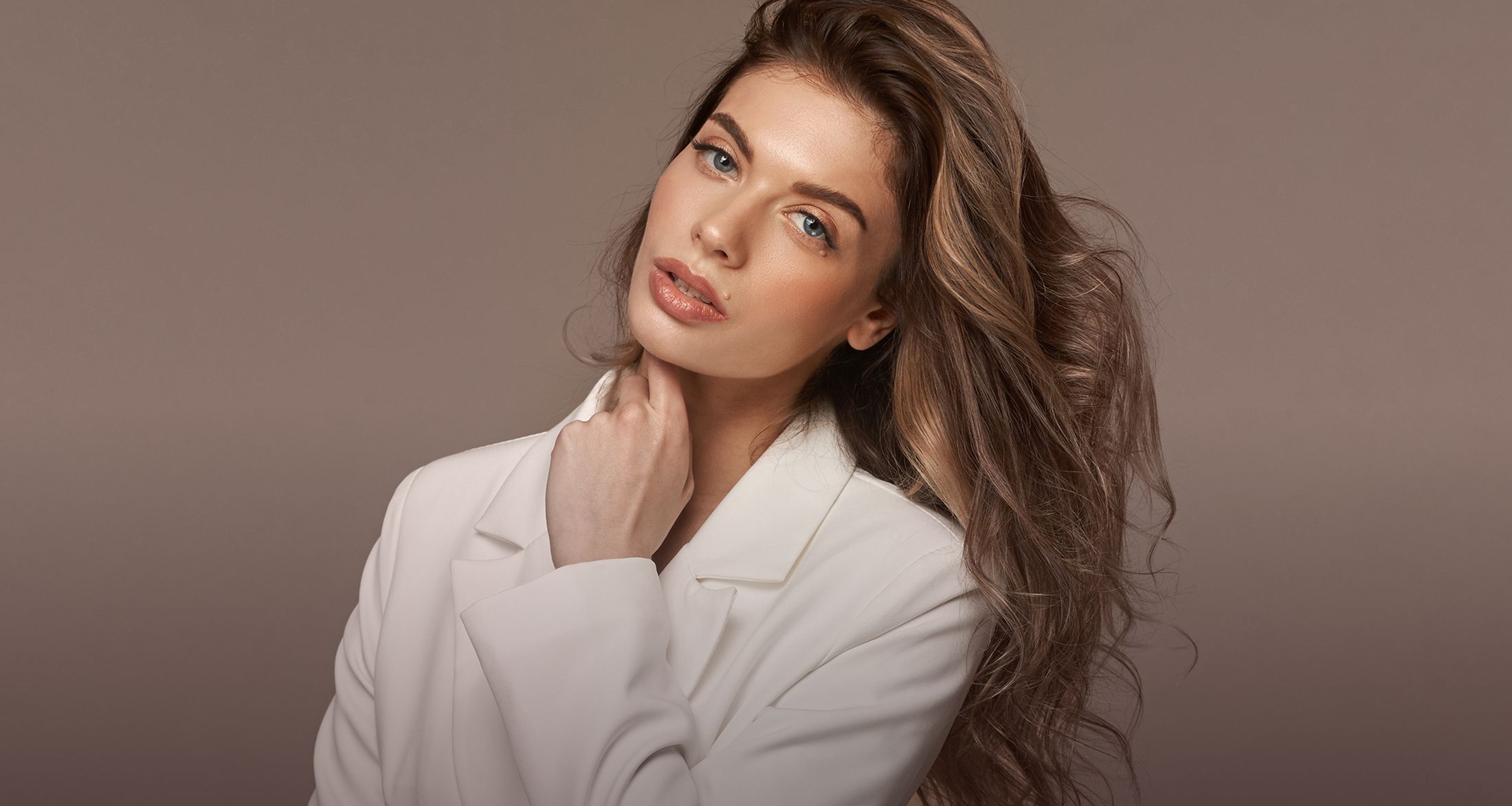 Denver plastic surgery model in a white blazer.