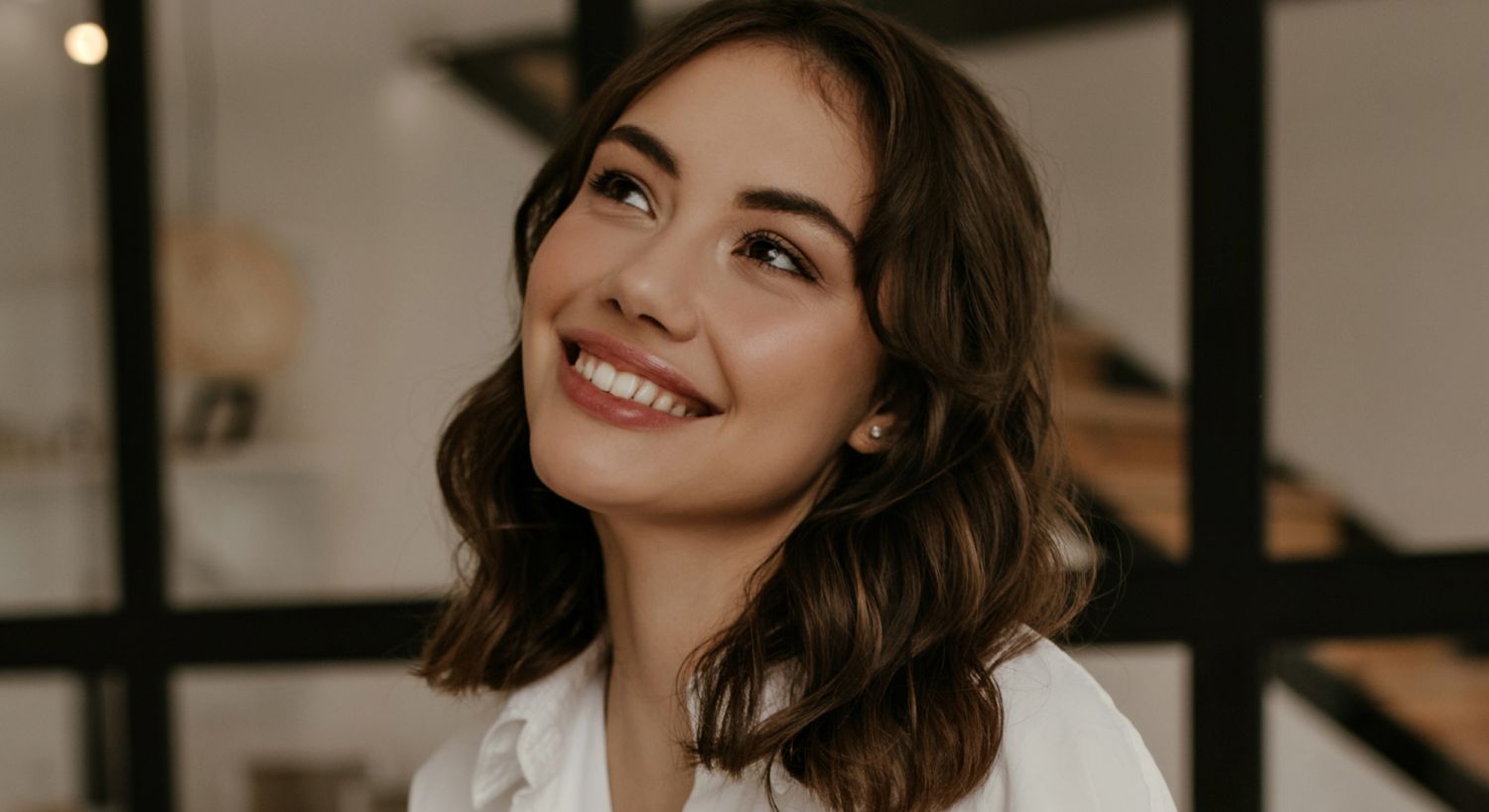 Smiling woman in a cozy indoor environment.